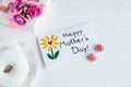 Mother day card on white background. Breakfast, carnation gift and a postcard made by the child for mom. Text Happy