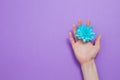 Mother day. Closeup woman hand holding blue flower isolated on purple background. Mothers holidays. Flower top view Royalty Free Stock Photo
