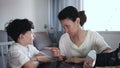 mother discussing misbehavior with tween son while they sitting at home table