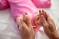 Mother or doctor massaging small baby's foot