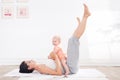 Mother does gymnastics with her baby