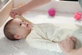 Mother doing massage on her healthy infant baby. Caring Woman Making Gymnastics To little Baby Royalty Free Stock Photo