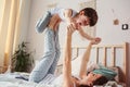 mother doing morning gymnastics with happy toddler son in bed. Royalty Free Stock Photo