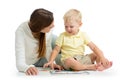 Mother doing playing puzzle toy together with her kid son on floor isolated on white background