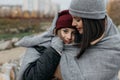 Mother and doughter teenager are walking on the street in warm autumn clothes