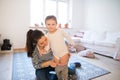 Mother dressing her daughter in the morning their living room