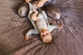 Mother dressing her newborn baby son lying on bed Royalty Free Stock Photo