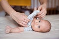 Mother dressing her newborn baby son lying on bed Royalty Free Stock Photo