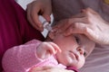 mother dribble medication in baby ear. Ear drops Royalty Free Stock Photo