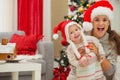 Mother and eat smeared baby in Christmas hats