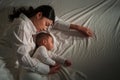 mother embraces the infant baby sleeping together in bed at night Royalty Free Stock Photo