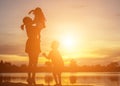 Mother encouraged her son outdoors at sunset, silhouette concept Royalty Free Stock Photo