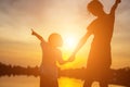 Mother encouraged her son outdoors at sunset, silhouette concept Royalty Free Stock Photo