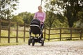 Mother Exercising By Running Whilst Pushing Baby Buggy Royalty Free Stock Photo