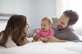 Mother father and baby child on a white bed. Royalty Free Stock Photo