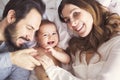 Mother father and baby child on a white bed. Royalty Free Stock Photo