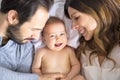 Mother father and baby child on a white bed. Royalty Free Stock Photo