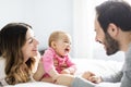 Mother father and baby child on a white bed. Royalty Free Stock Photo