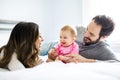 Mother father and baby child on a white bed. Royalty Free Stock Photo