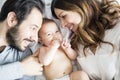 Mother father and baby child on a white bed. Royalty Free Stock Photo