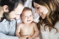 Mother father and baby child on a white bed. Royalty Free Stock Photo