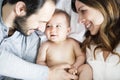 Mother father and baby child on a white bed. Royalty Free Stock Photo