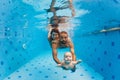 Mother, father with baby swimming, diving underwater in pool Royalty Free Stock Photo