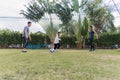 Mother, father and child daughter playing soccer outside in nature a field garden park