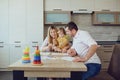 Mother, father and child draw together at the table.