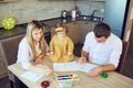 Mother, father and child draw together at the table. Royalty Free Stock Photo