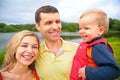 Mother and father with child on hands outdoors. wi