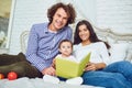 Mother, father and child are reading a book at home Royalty Free Stock Photo