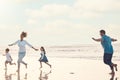 Mother, father and children on the beach to dance together while outdoor for travel or vacation in summer. Sunset Royalty Free Stock Photo