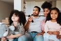 Mother, father and children on sofa, watching tv and happy family bonding together in living room. Home, happiness and Royalty Free Stock Photo