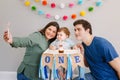 Mother father dad taking selfie with child kid toddler. Caucasian family with baby boy celebrating first birthday at home. Cupcake Royalty Free Stock Photo