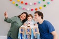 Mother father dad taking selfie with child kid toddler. Caucasian family with baby boy celebrating his first birthday at home. Royalty Free Stock Photo