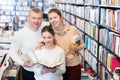 mother, father and daughte standing in library
