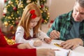 Mother, father and daughter drawing on Christmas day Royalty Free Stock Photo
