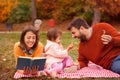 Mother, father and daughter spending time together on the grass in the park Royalty Free Stock Photo