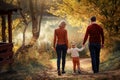 Mother father and daughter are walking along the forest path three and around the trees with yellow leaves Royalty Free Stock Photo