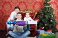 Mother, father and daugther give gifts near Christmas tree Royalty Free Stock Photo