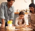 Mother, father and girl with dough for cooking in kitchen with rolling pin, happy and teaching with support. Family Royalty Free Stock Photo