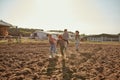 Mother and father go while kids running on field Royalty Free Stock Photo