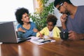 Mother and father helping daughter to do homework learning to calculate