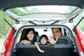 Mother, father, and his daughter inside a car look out from back windows Royalty Free Stock Photo