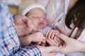 Mother and father holding hand of sleeping baby