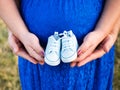 Mother and father holding in their hands a pair of tiny baby sneakers Royalty Free Stock Photo