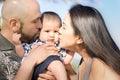 Family portrait, mom and dad giving their baby a kiss Royalty Free Stock Photo