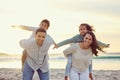 Mother, father and kids piggyback on beach for family holiday, summer vacation and weekend. Nature, travel and portrait Royalty Free Stock Photo