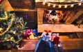 Mother father and kids sitting at cosy fireplace on winter time - Lovely family resting together on woolen socks at home fire Royalty Free Stock Photo